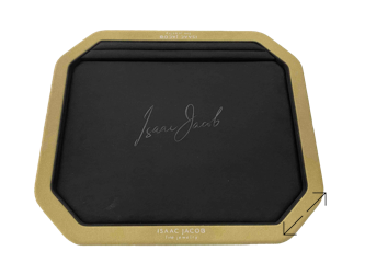 A black rectangular cut pan tray with rounded corners, featuring a microfiber frame and a signature in the center; design and manufacturing by Swiss Packaging of New York and Switzerland