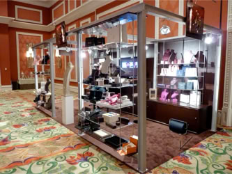 Couture Show: Las Vegas trade show exhibit in a room with patterned carpet and walls, containing various jewelry and watch boxes and displays design and manufacturing by Swiss Packaging of New York and Switzerland