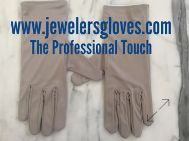 Two beige jewelers gloves on a marble surface with text above reading "www.jewelersgloves.com The Professional Touch." manufactured by Swiss Packaging of New York and Switzerland