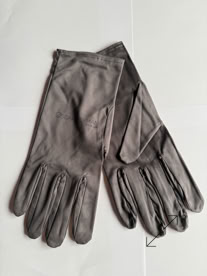 A pair of gray jewelers gloves on a white surface manufactured by Swiss Packaging of New York and Switzerland