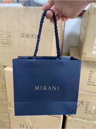 A blue shopping bag with "Mikani" written on it, created by Swiss Packaging