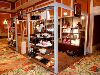 The Couture Show display booth with shelves holding various watch and jewelry boxes and displays set in a room with patterned carpet and ornate walls design and manufacturing by Swiss Packaging of New York and Switzerland