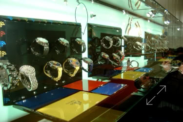 Display case with various Jacob and Co. watches on stands, featuring different designs and colors, design and design by Swiss Packaging of New York and Switzerland