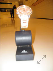 A Jacob & Co wristwatch displayed on a blue leatherette stand design and design by Swiss Packaging of New York and Switzerland