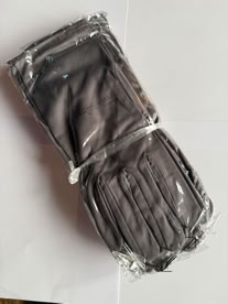A bundle of gray gloves in clear plastic packaging on a white surface manufactured by Swiss Packaging of New York and Switzerland