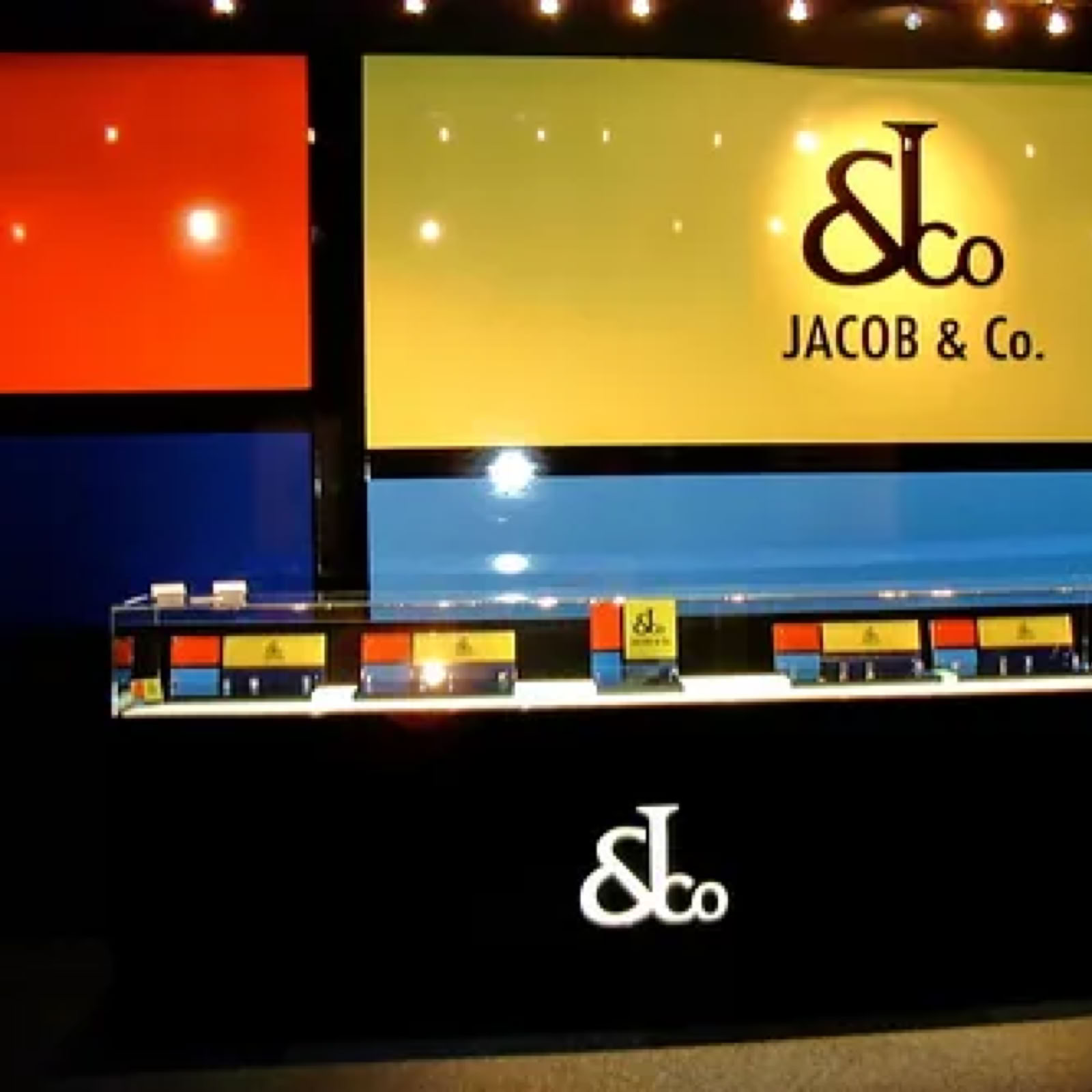 Final retail display environment for Jacob & Co Baselworld exhibition stand featuring integrated lighting, showcases, and brand architecture by Swiss Packaging