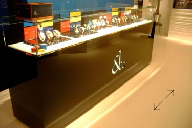 Basel Fair Display case with various Jacob & Co. wristwatches on stands, set on a glossy black counter with a logo design by Swiss Packaging of New York and Switzerland
