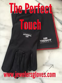 Black jewelers gloves and a black jewelers cloth with red trim on a marble surface, with red text reading "The Perfect Touch" and a website URL www.jewelersgloves.com at the bottom manufactured by Swiss Packaging of New York and Switzerland