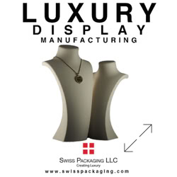 Two Jewelry busts, one with a necklace, with text above reading "Luxury Display Manufacturing" and below "Swiss Packaging LLC" with a red cross logo manufactured by Swiss Packaging of New York and Switzerland