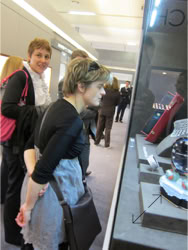 A group of people standing and  looking at a Swiss Packaging designed Basel Fair exhibit stand Jewelry display 