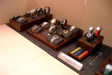 Display of various David Yurman wristwatches on wooden stands, with additional watch straps on the side design and designed and manufactured by Swiss Packaging of New York and Switzerland