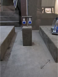 Basel Display Case A pair of blue and silver earrings displayed on a stand in a jewelry store, with other jewelry items visible in the background.