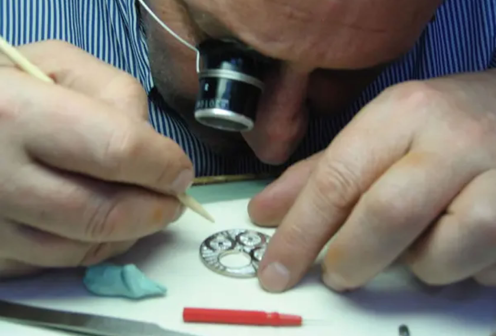 Hand-assembly and detailing of watch components, representing the final stage of refinement before completion.