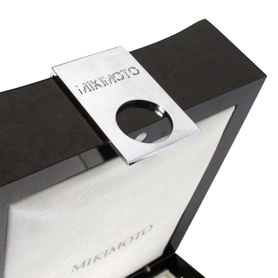 Close-up of precision stainless steel tab lock integrated into Mikimoto luxury jewelry packaging box